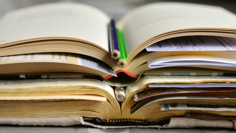 aufgeschlagene Bücher mit Stiften und Lesezeichen